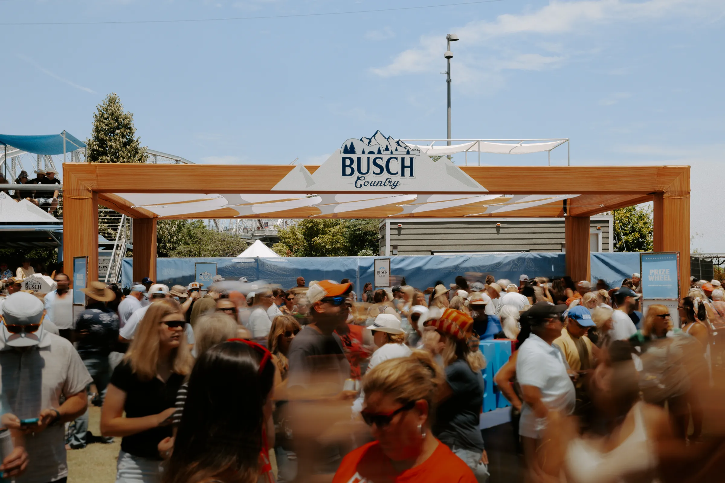 Timber Busch Country entry arch and mountain logo above a festival crowd
