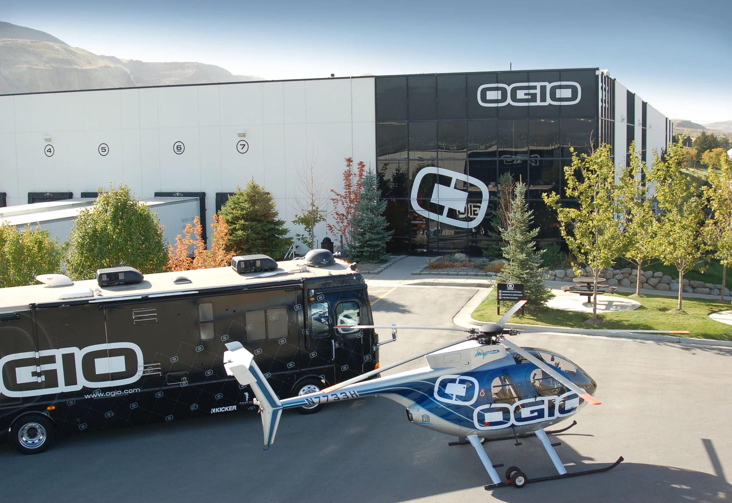 OGIO headquarters exterior with a branded vehicle and helicopter