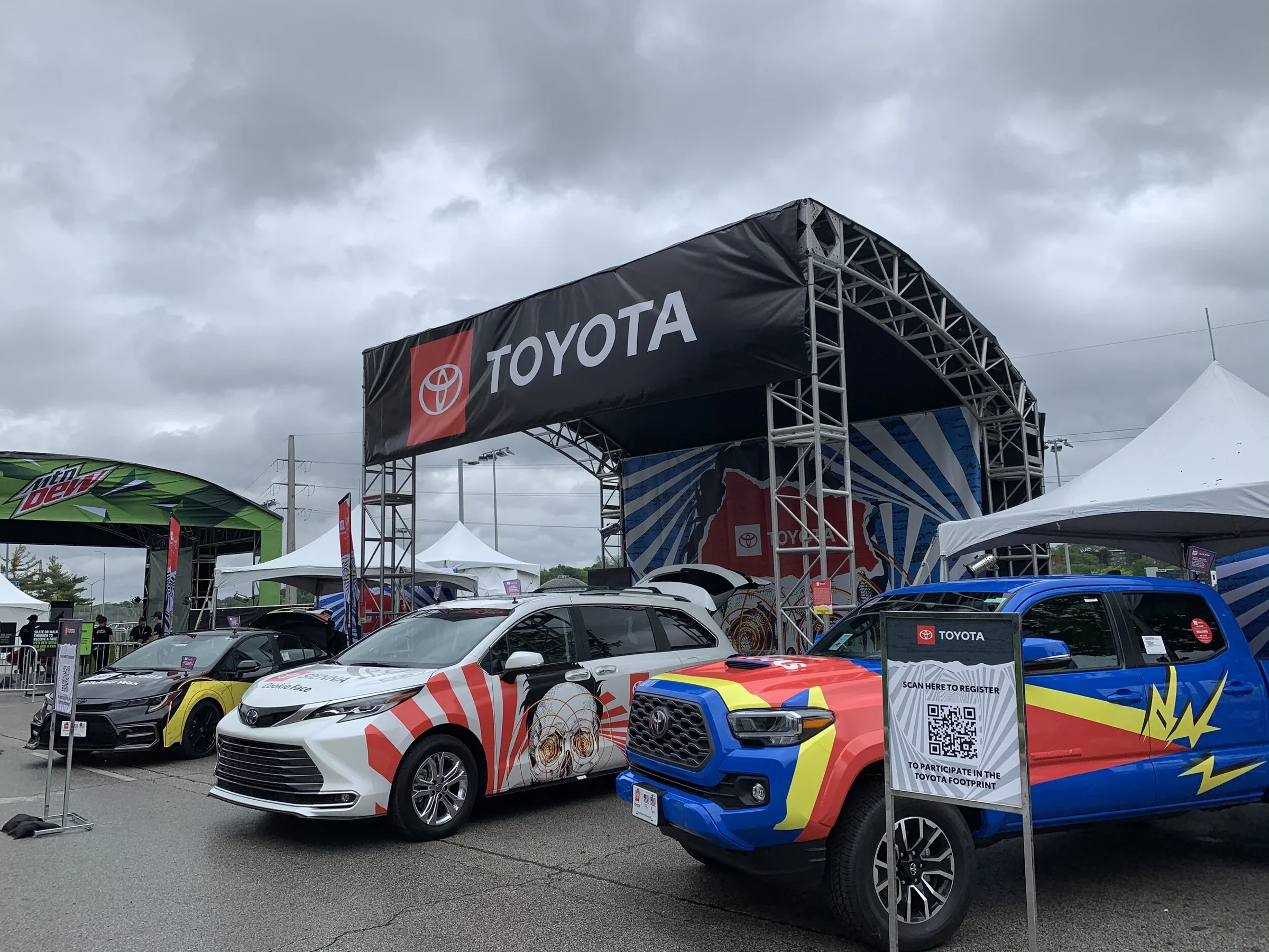 Lineup of wrapped Toyota vehicles beside the festival main stage