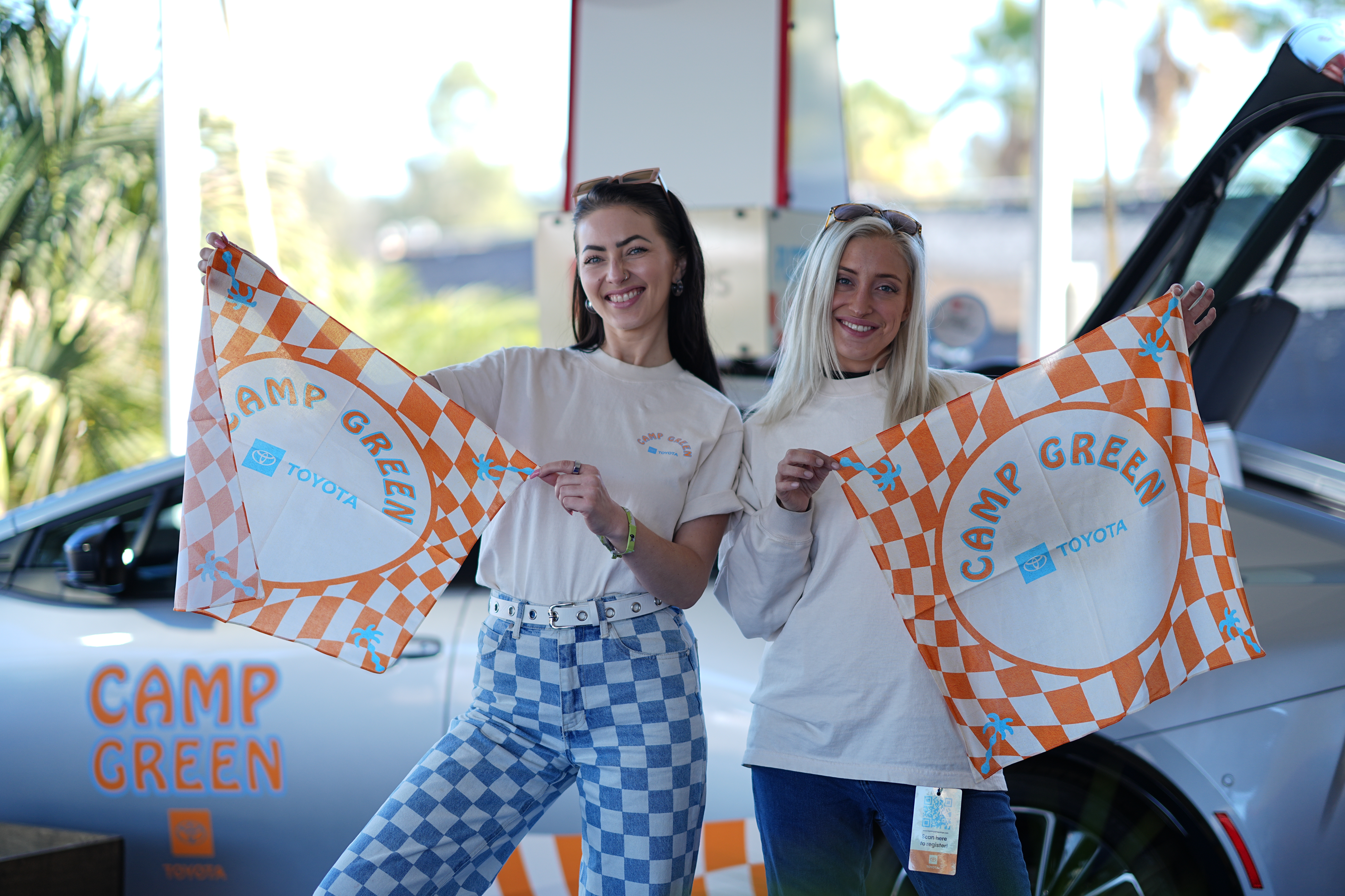 Two guests holding Camp Green towels at the Toyota Prius activation