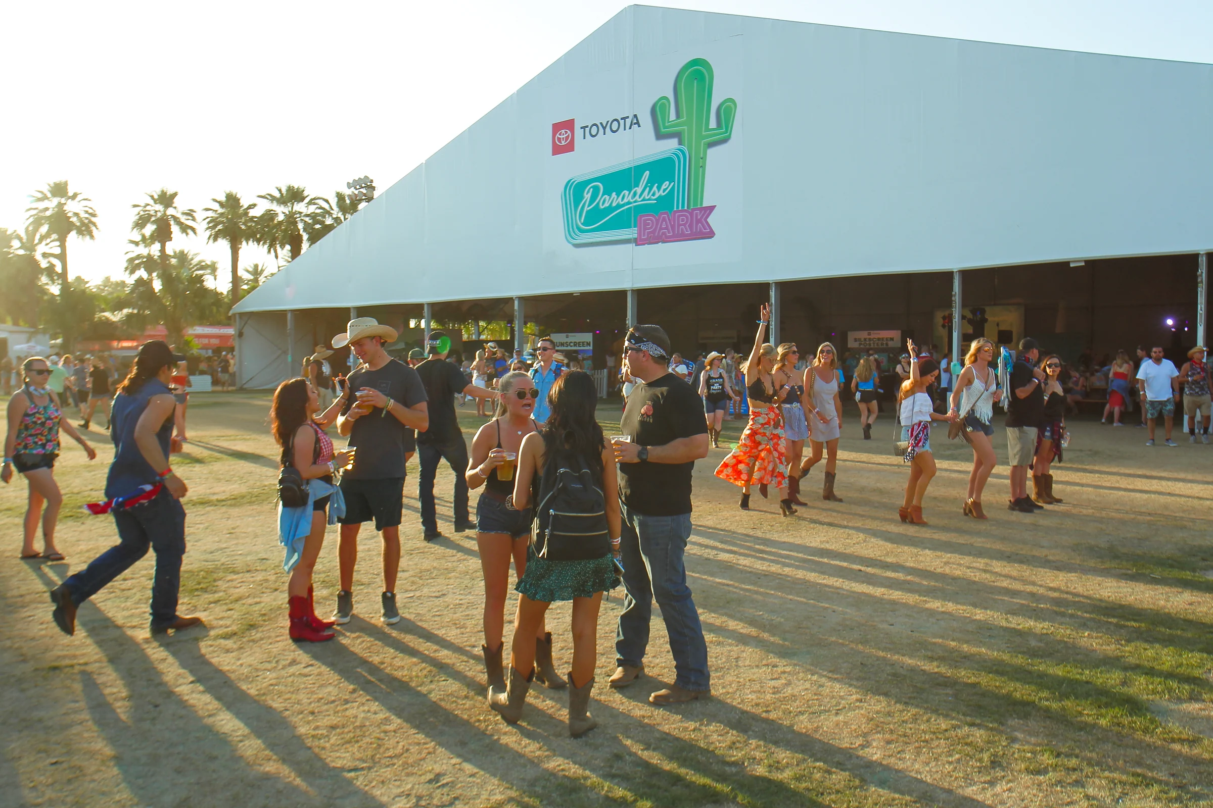 Festival crowd walking past the Toyota Paradise Park tent and signage at Stagecoach