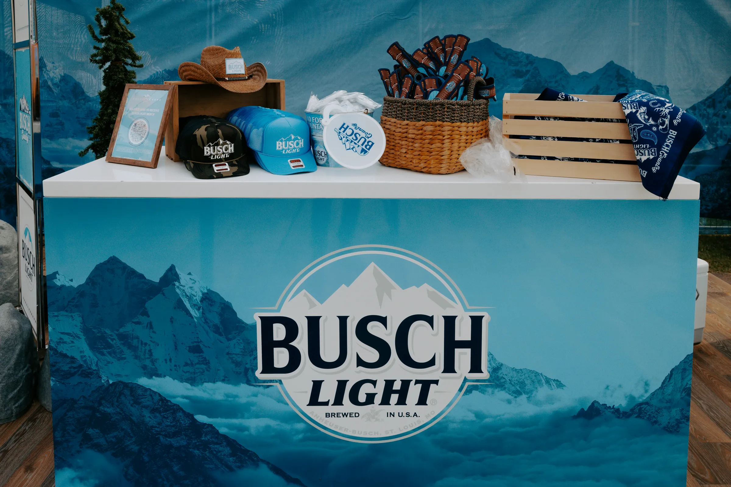 Close view of Busch Light premiums — hats, frisbees, bandanas and koozies on the branded counter