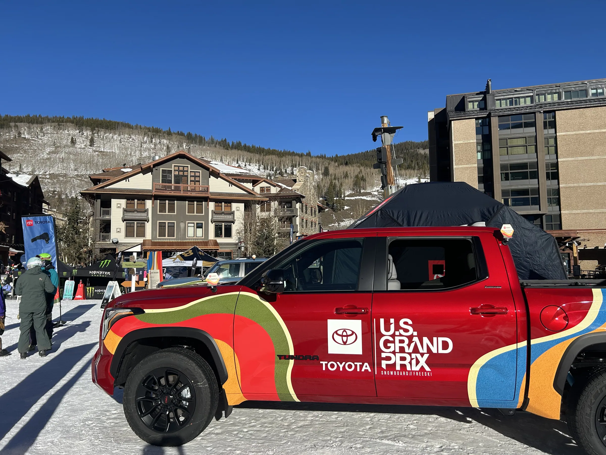 Red Toyota Tundra in U.S. Grand Prix livery parked in the snow below the mountain
