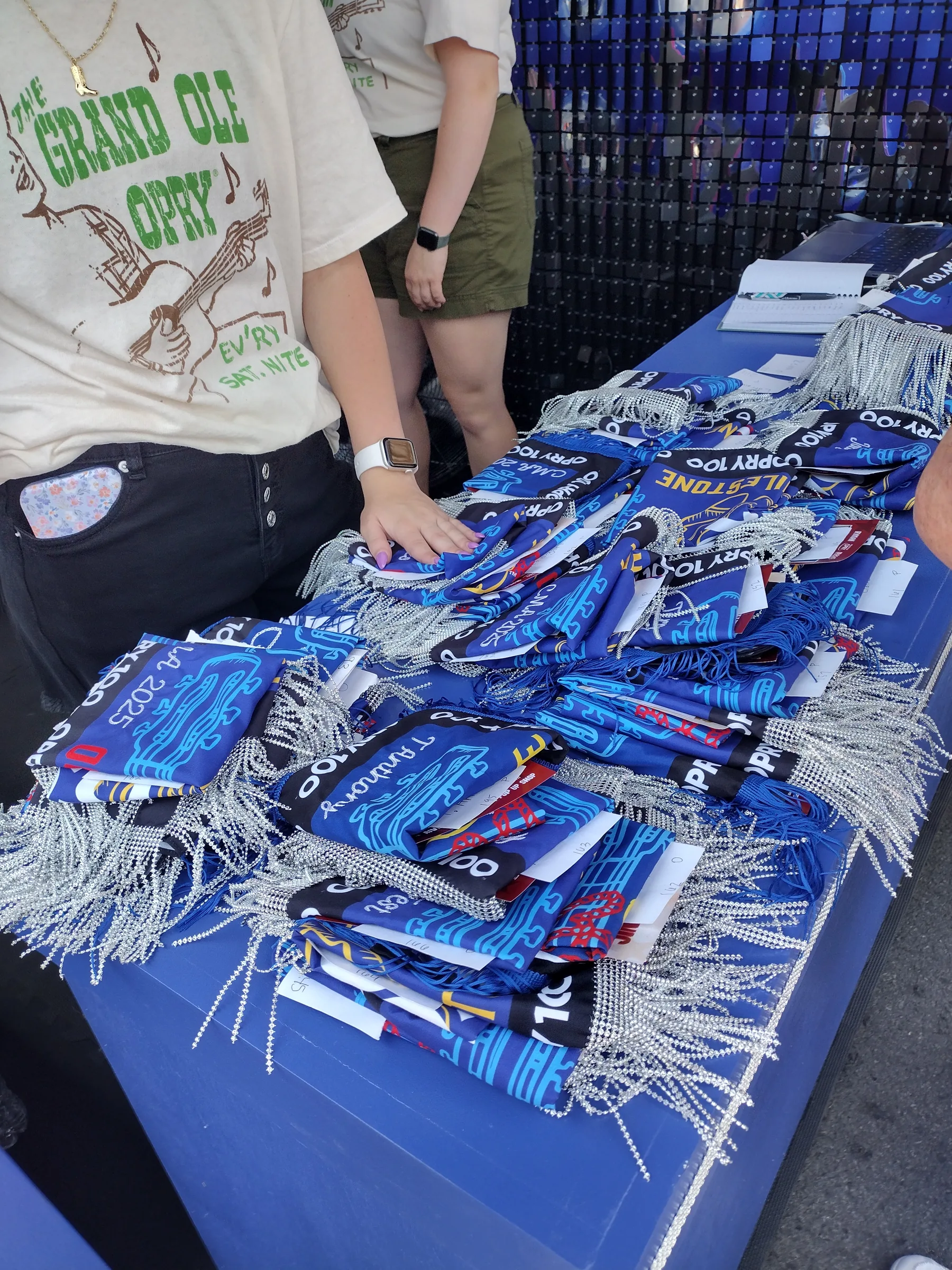 Detail of custom Opry 100 bandanas laid out on the merchandise table